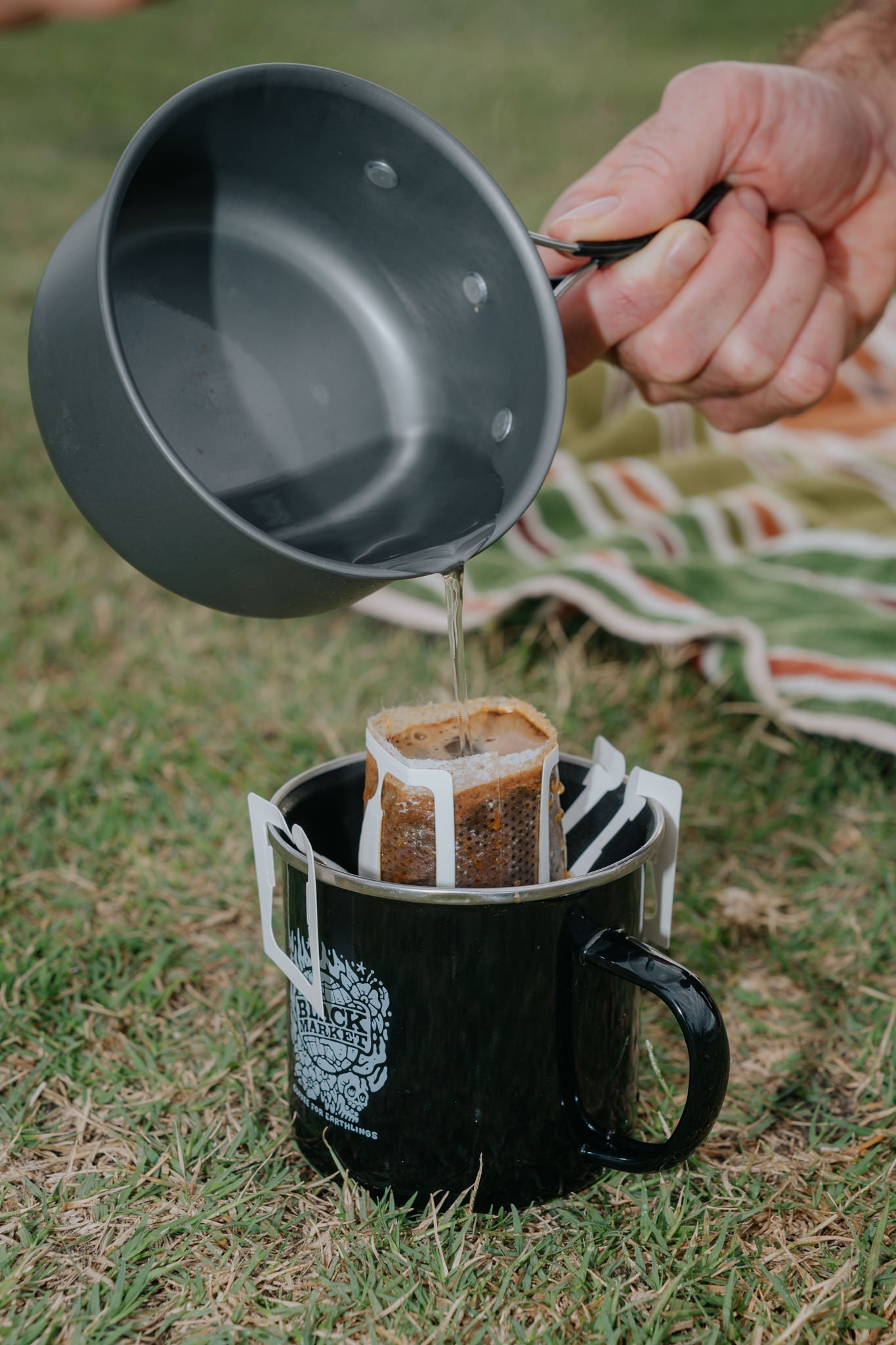 black market coffee drip bag being used on a camps stove in a park in Bondi 