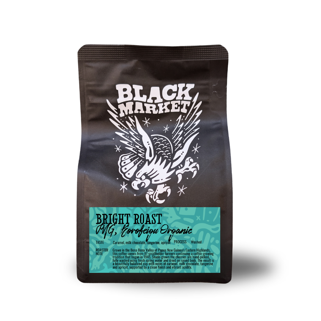 A stand-up coffee bag from Black Market Coffee Roasters, featuring a dark brown body with a white eagle graphic and a teal label at the bottom that reads 'Bright Roast' and 'Peruvian Organic'.
