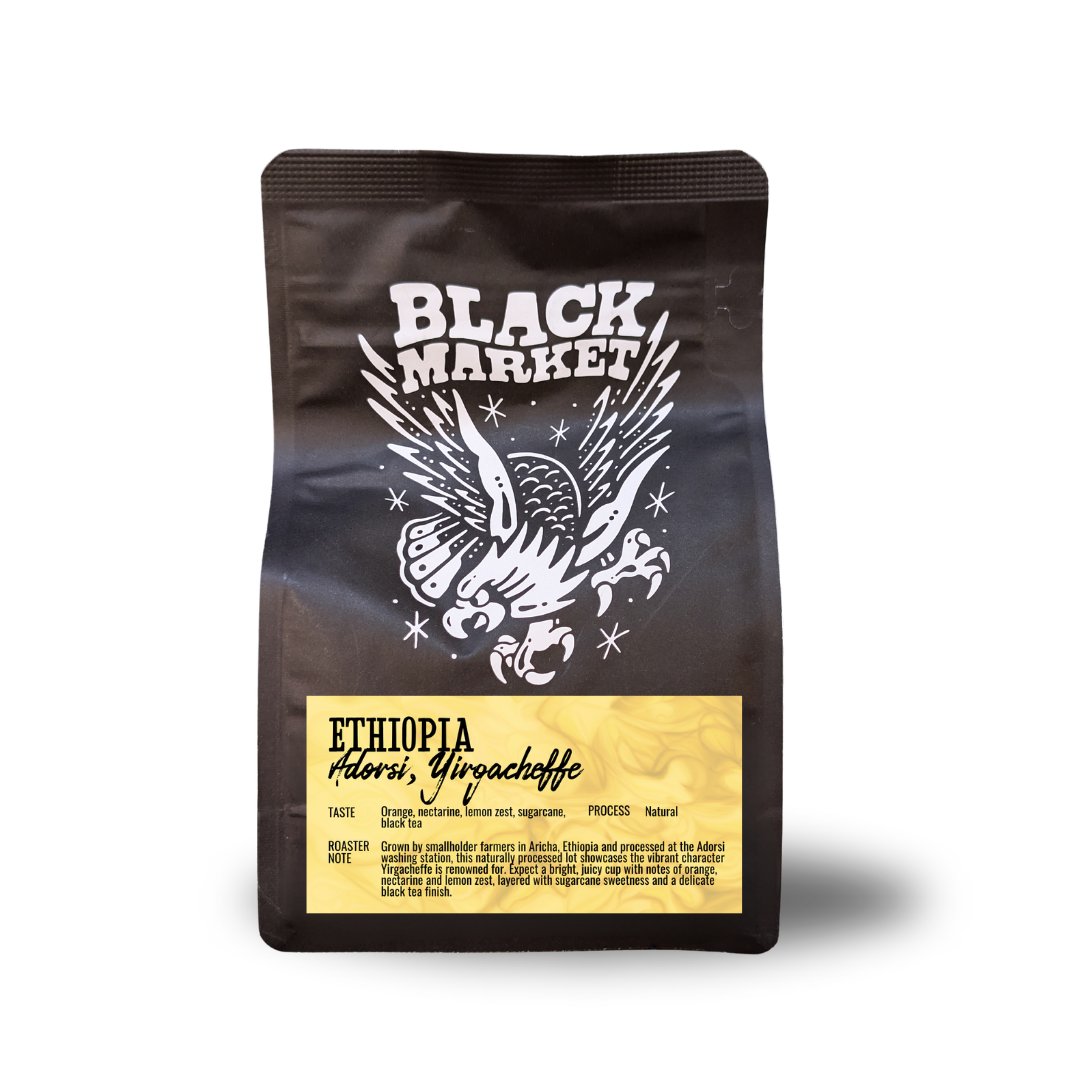 A black stand-up pouch of Black Market Ethiopia Adorsi, Yirgacheffe whole bean coffee on a white background.