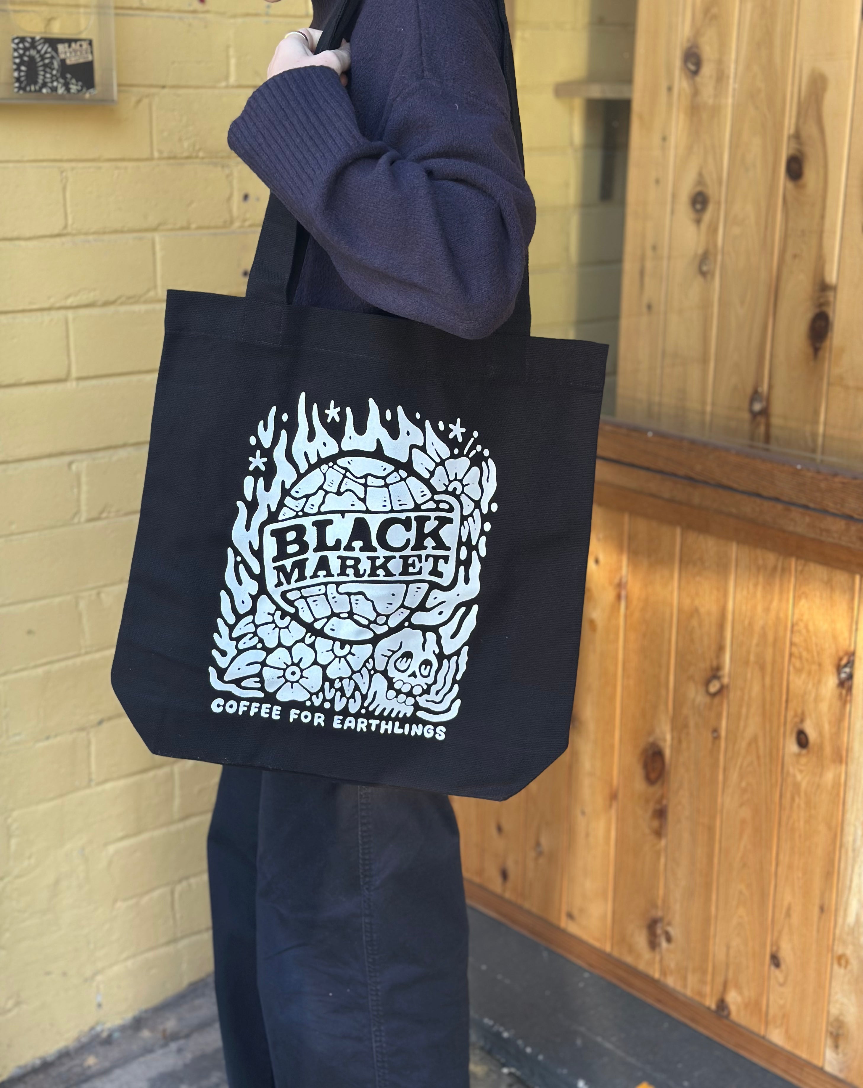 Lifestyle photo of BlackMarket Coffee tote bag being carried - everyday use