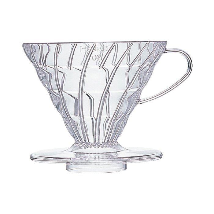 A clear plastic V60 coffee dripper with a 60 degree angled design, featuring large hole in the middle and spiral ridges around the edges.